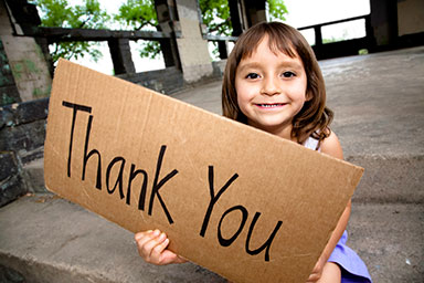 Young girl holding a thank you sign