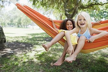 Two young girls sitting in a hammock